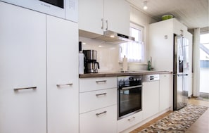 Enjoy cooking in this well-equipped kitchen with a coffee maker, oven, and refrigerator.