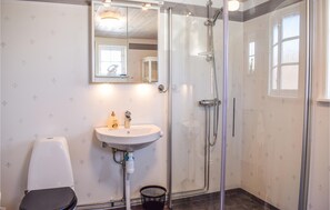 Une salle de bain avec une douche à parois de verre, un lavabo et des toilettes.