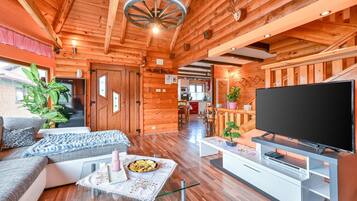 A cozy log cabin interior with a living room, kitchen, and dining area.