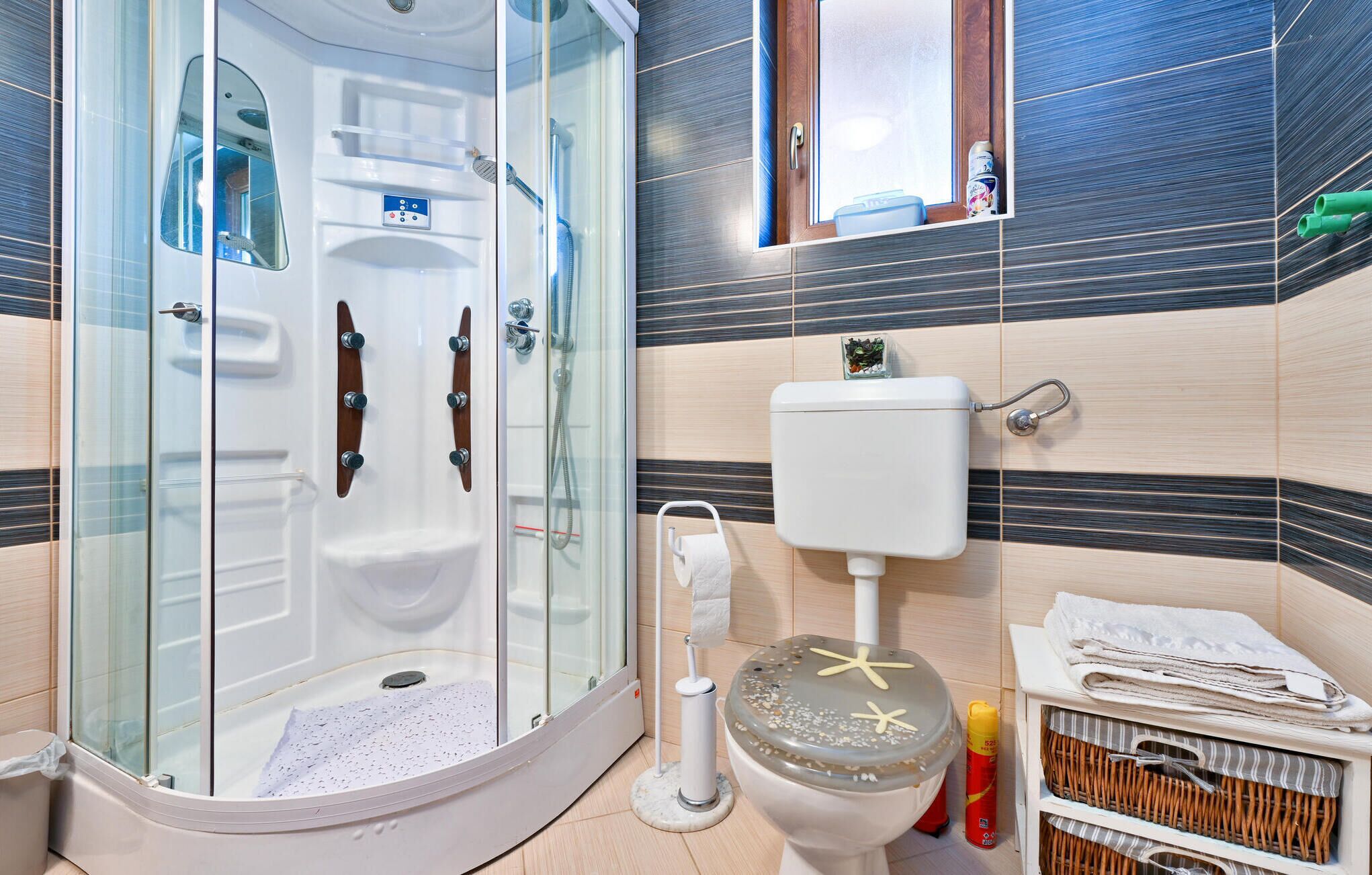 A modern bathroom with a glass-enclosed shower, a toilet, and a sink.