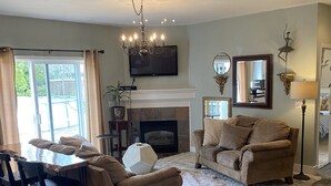 A living room with a fireplace, a dining area with a table and chairs, and a sofa. - World Track Championships-3 Bedroom Home. Car available. (Eugene)