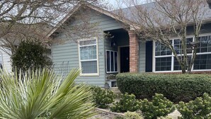 A house with a front yard featuring a rock garden, various shrubs, and a palm tree. - World Track Championships-3 Bedroom Home. Car available. (Eugene)