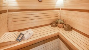 A sauna with wooden benches and benches, towels, and a potted plant. - Nice home in Damp with sauna (Damp)