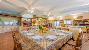 A dining area with a round table set for six, surrounded by wooden chairs. - Gorgeous home in Montalto di Castro (Montalto di Castro)