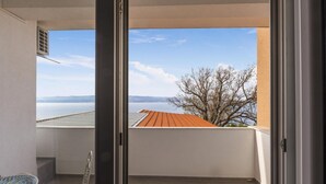 Een balkon met uitzicht op water en verre bergen.