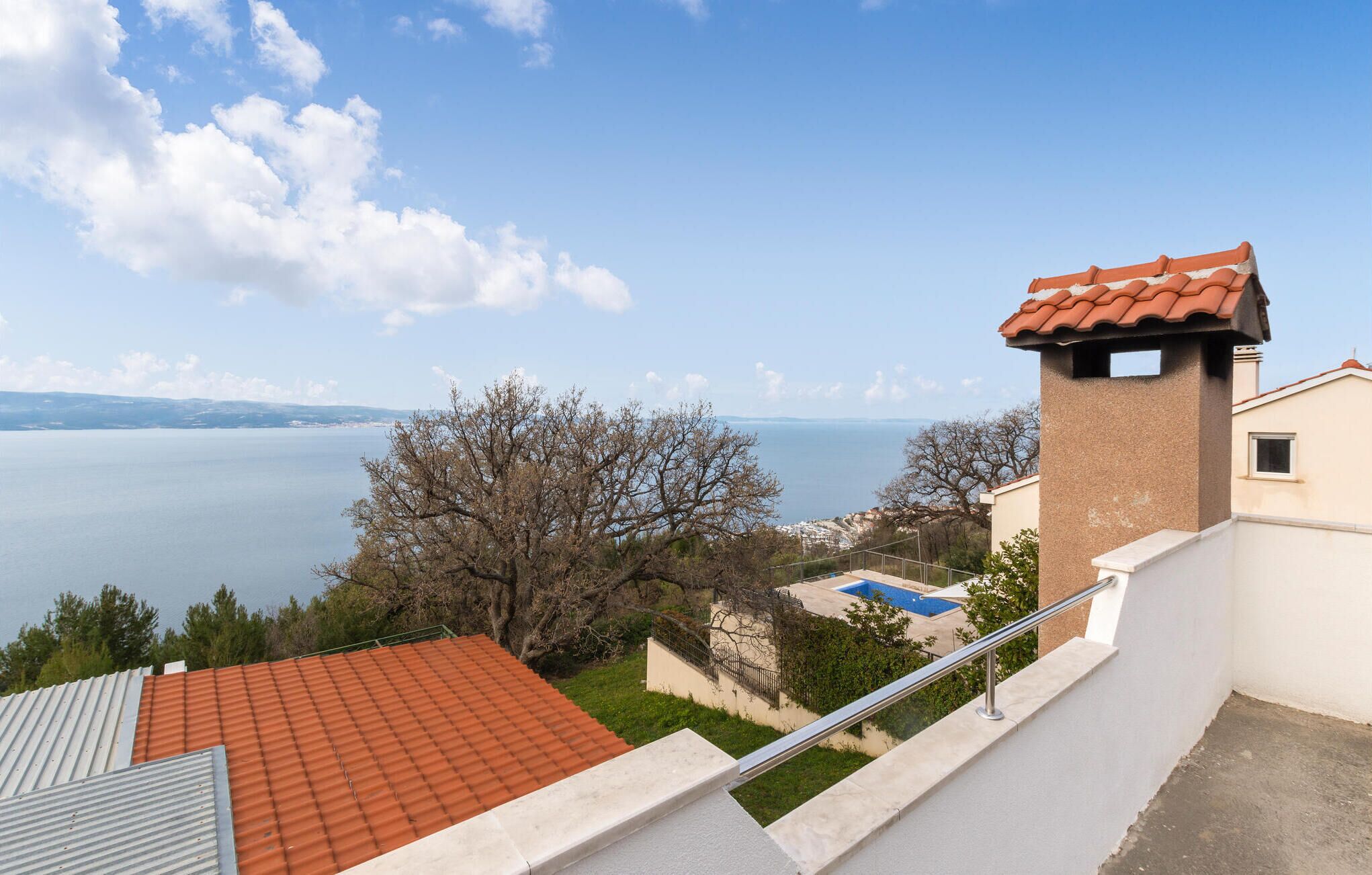 A residential building with a view of a lake and distant mountains.