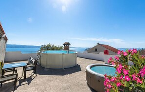 A rooftop terrace with a swimming pool, a table with chairs, and a view of the sea. - Lovely home in Jesenice Dugi Rat (Jesenice Dugi Rat)