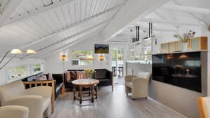 A spacious loft with high ceilings, a dining area, a kitchen, and a view of the outdoors. - Stunning home in Rømø with kitchen (Rømø)
