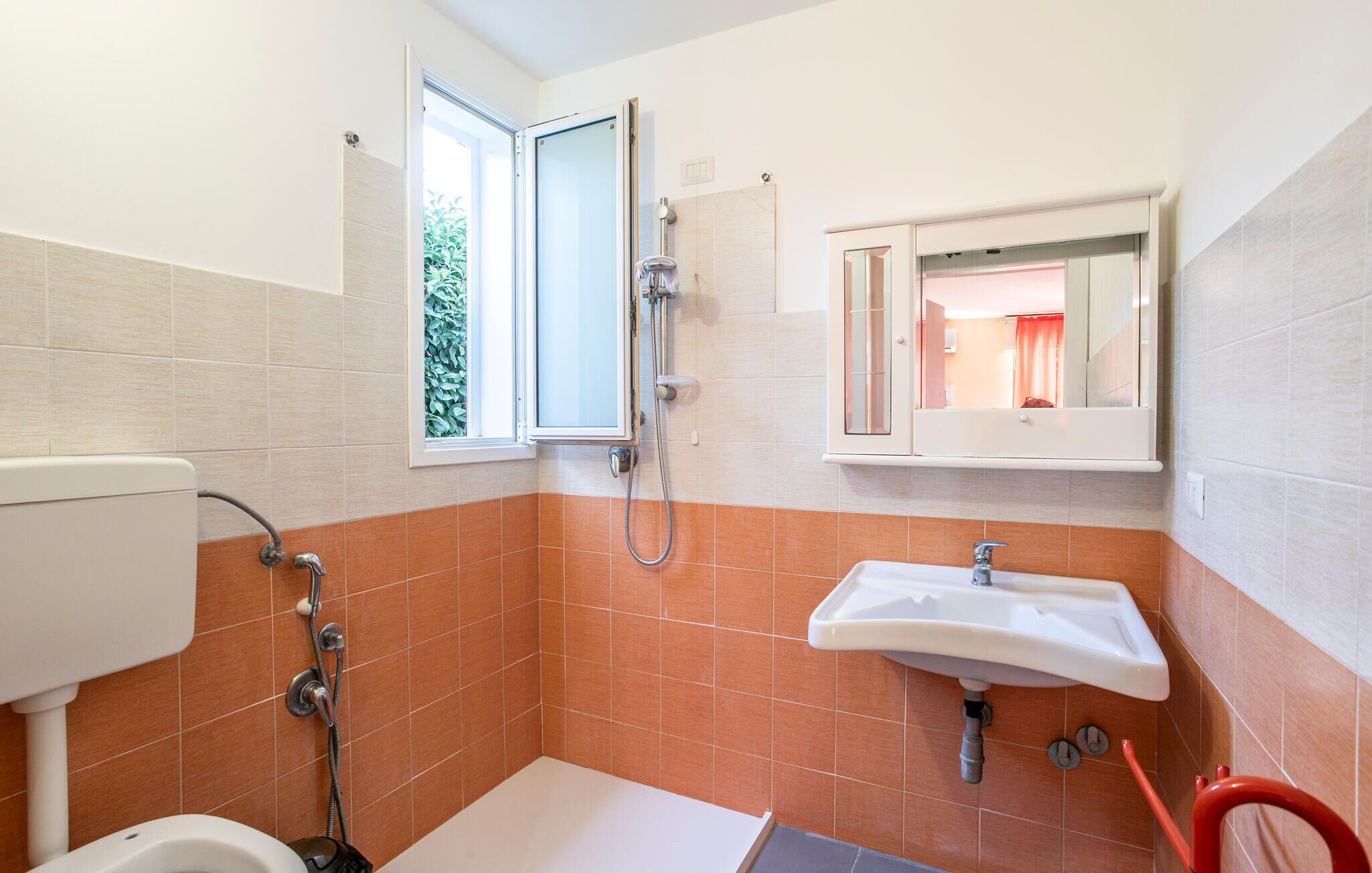 A bathroom with a toilet, shower, and sink.