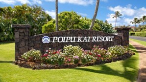 A stone sign with "POIPUI KAI RESORT" written on it, surrounded by a flower bed and palm trees. - Love Nest - Luxury Studio in tropical gardens with koi ponds, waterfalls (Koloa)