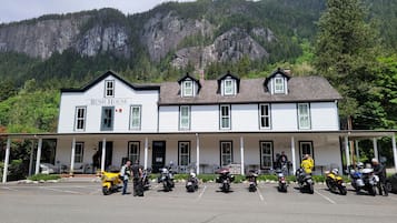 A two-story building named 'Bush House' with a porch, multiple windows, and a mountain backdrop.