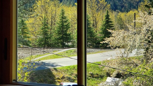 A mountain view through a window with a clear sky. - Bush House Inn (Index)