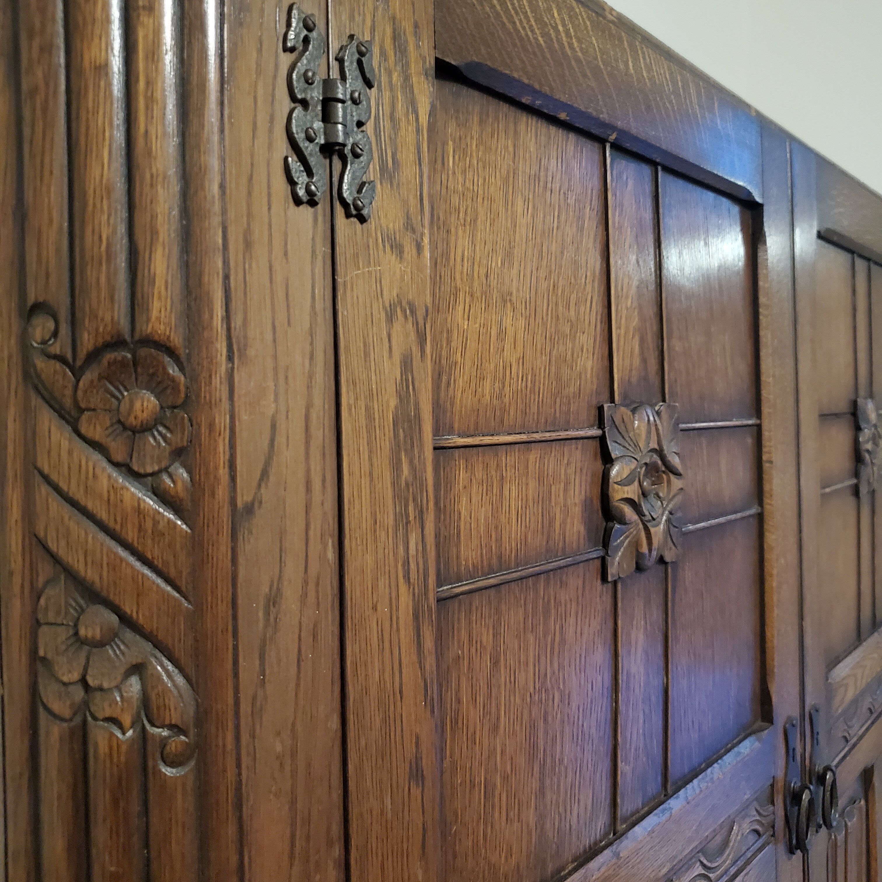 Een houten kast met ingewikkelde houtsnijwerken en een stevige metalen sluiting.