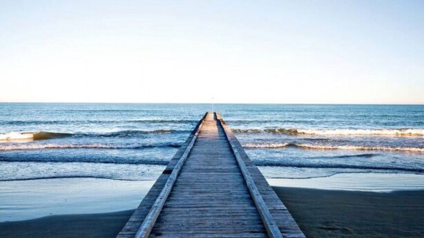 Eine hölzerne Steg, der sich ins Meer erstreckt.