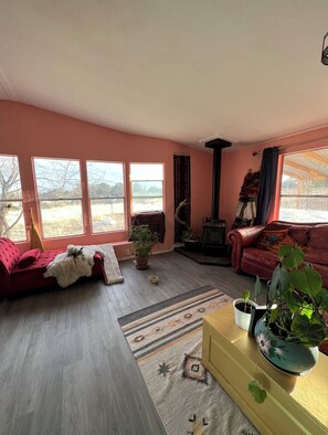 Cozy living room with a fireplace, comfortable seating area, and natural light.