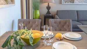 A dining table with plates, glasses, and a bowl of greens.