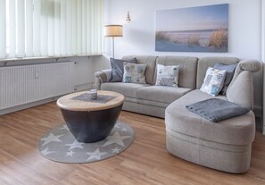 Ein Wohnzimmer mit einer Couch, einem Couchtisch und einer Lampe.