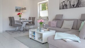 En moderne stue med spiseplads, sofa og sofabord.