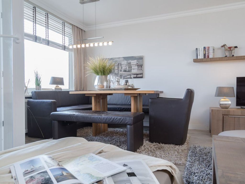 A modern living room with a sofa, a coffee table, and a TV stand.