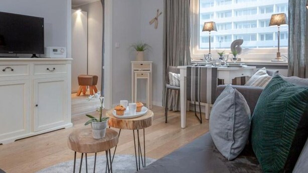 Un salon moderne avec un canapé, une table basse et un coin repas.