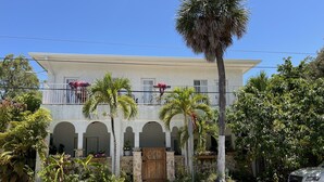 A two-story building with a balcony, arched windows, and a gated entrance. - Clean, New, Spacious, in Coconut Grove! (Miami)