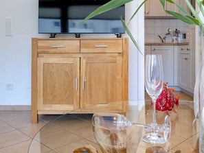 Une cuisine moderne avec des meubles en bois, une table en verre et un objet décoratif en forme de poisson.