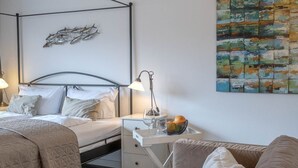 Une chambre à coucher avec un lit, une table de chevet, une lampe et un tableau au mur.