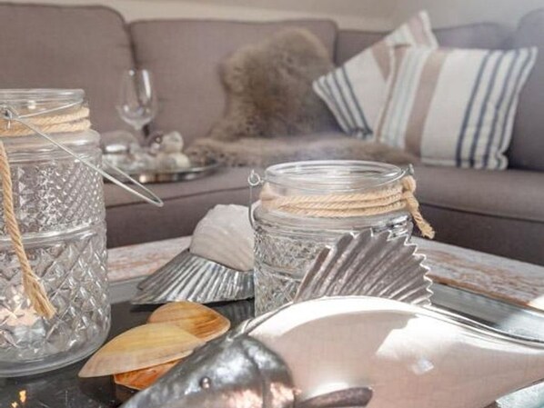 A dining table with glass jars, a fish, and a decorative shell.