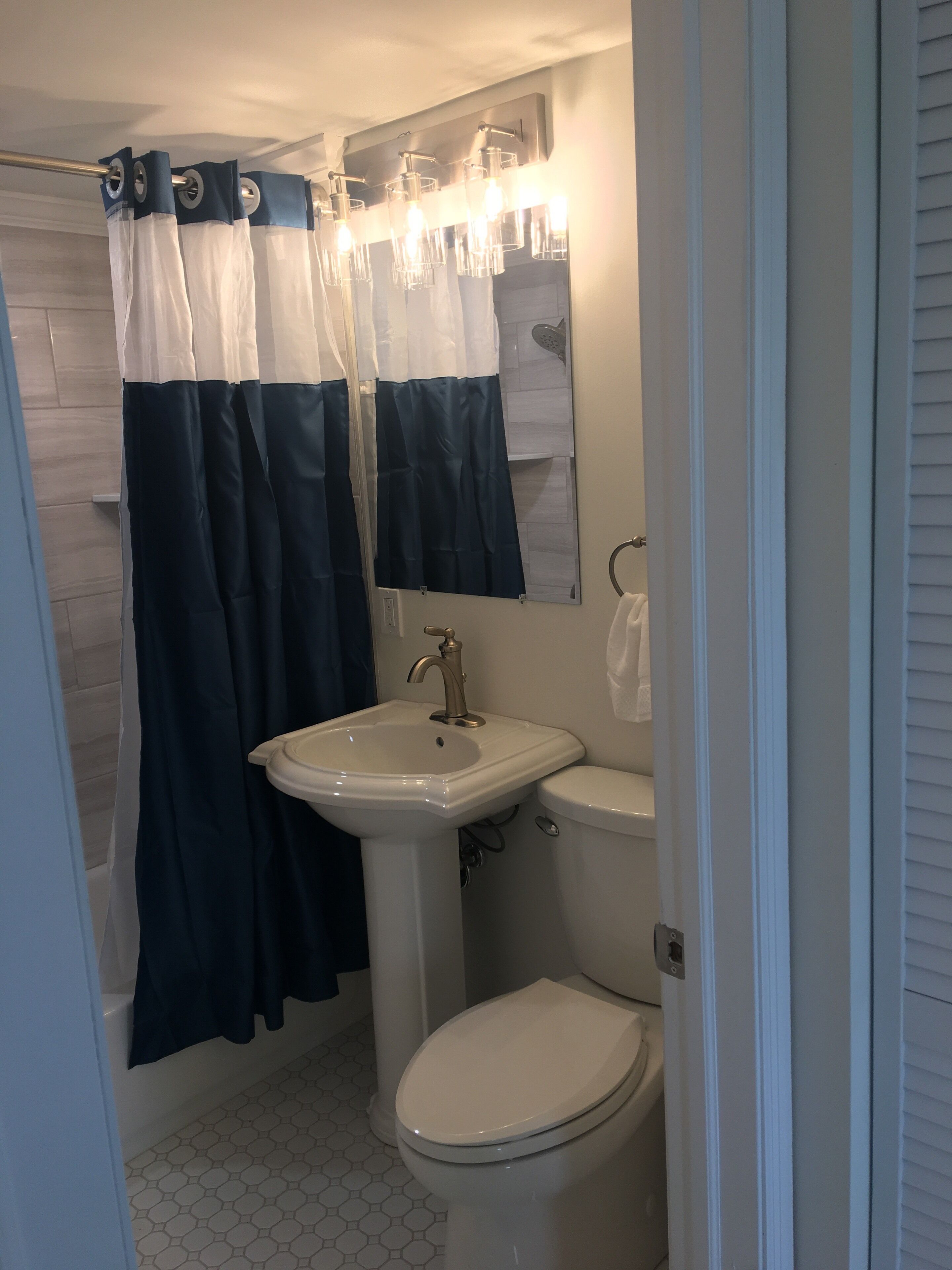 A bathroom with a white sink, a toilet, and a shower curtain.