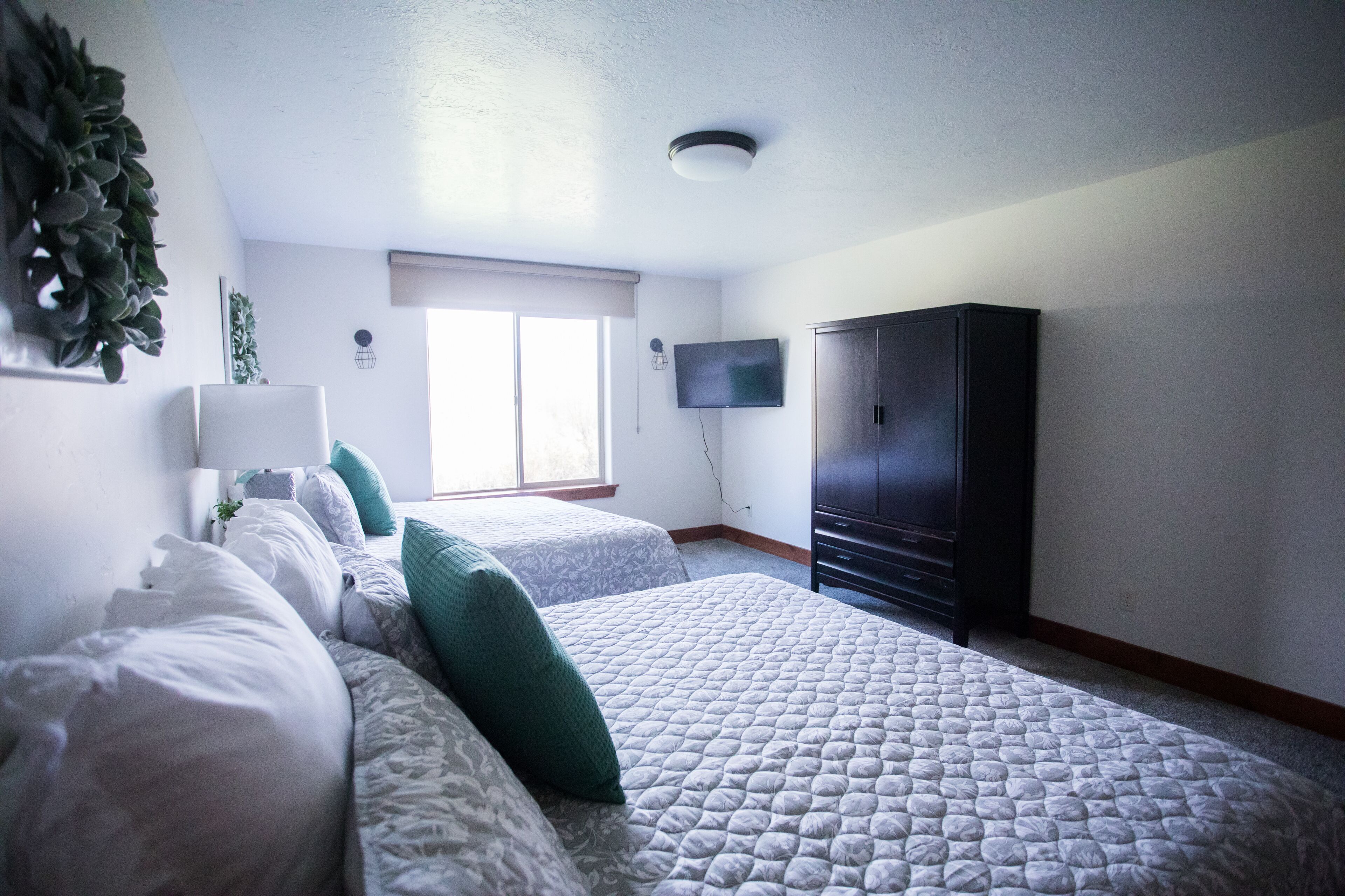 Un dormitorio con dos camas, un televisor y un armario.