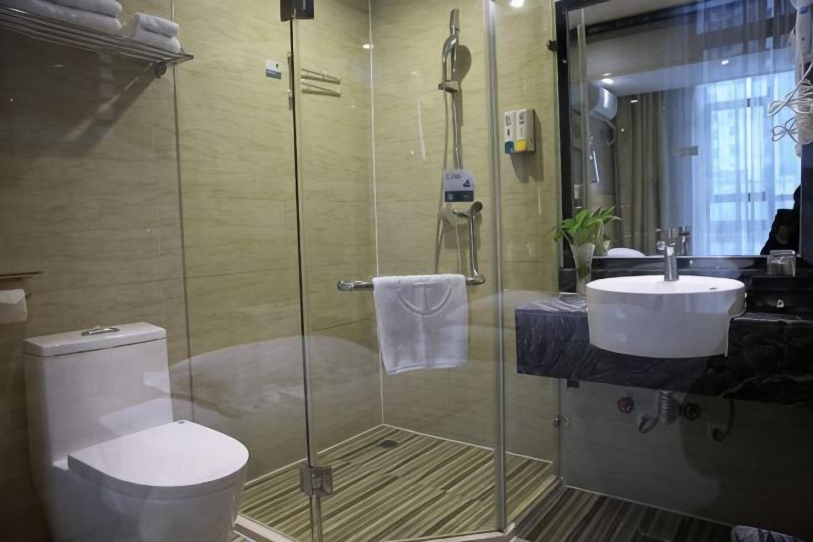Un baño moderno con ducha de vidrio, inodoro y lavabo.