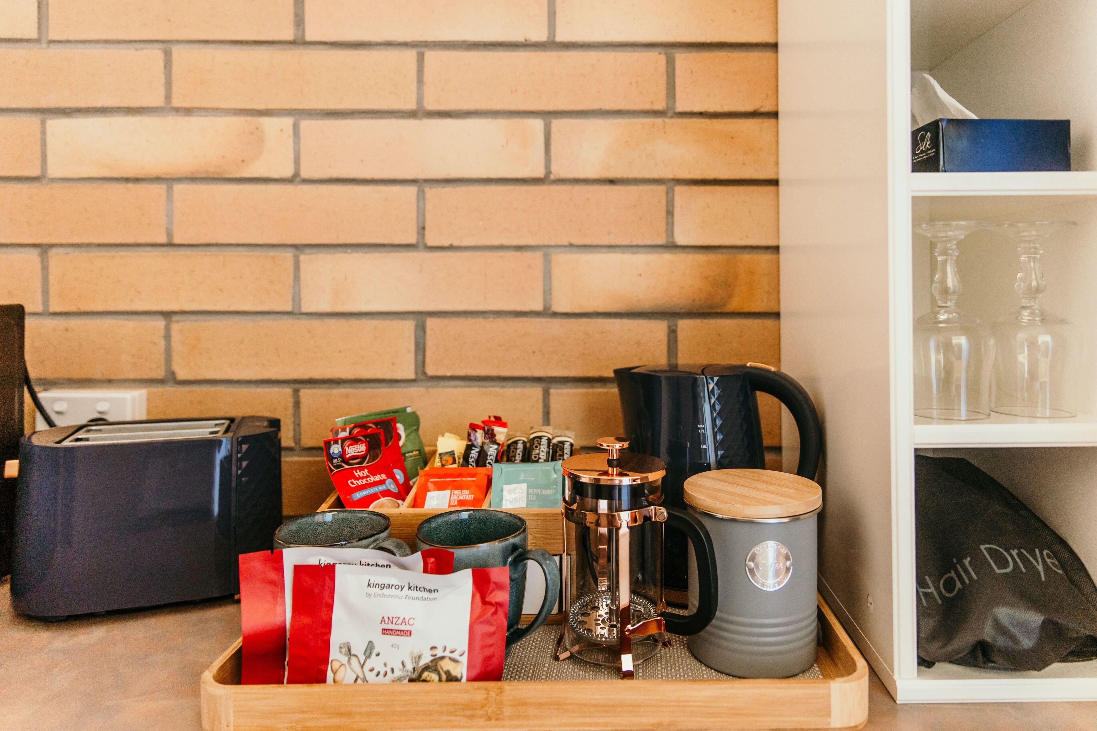 Uma bancada de cozinha com uma cafeteira, uma torradeira e diversos utensílios.