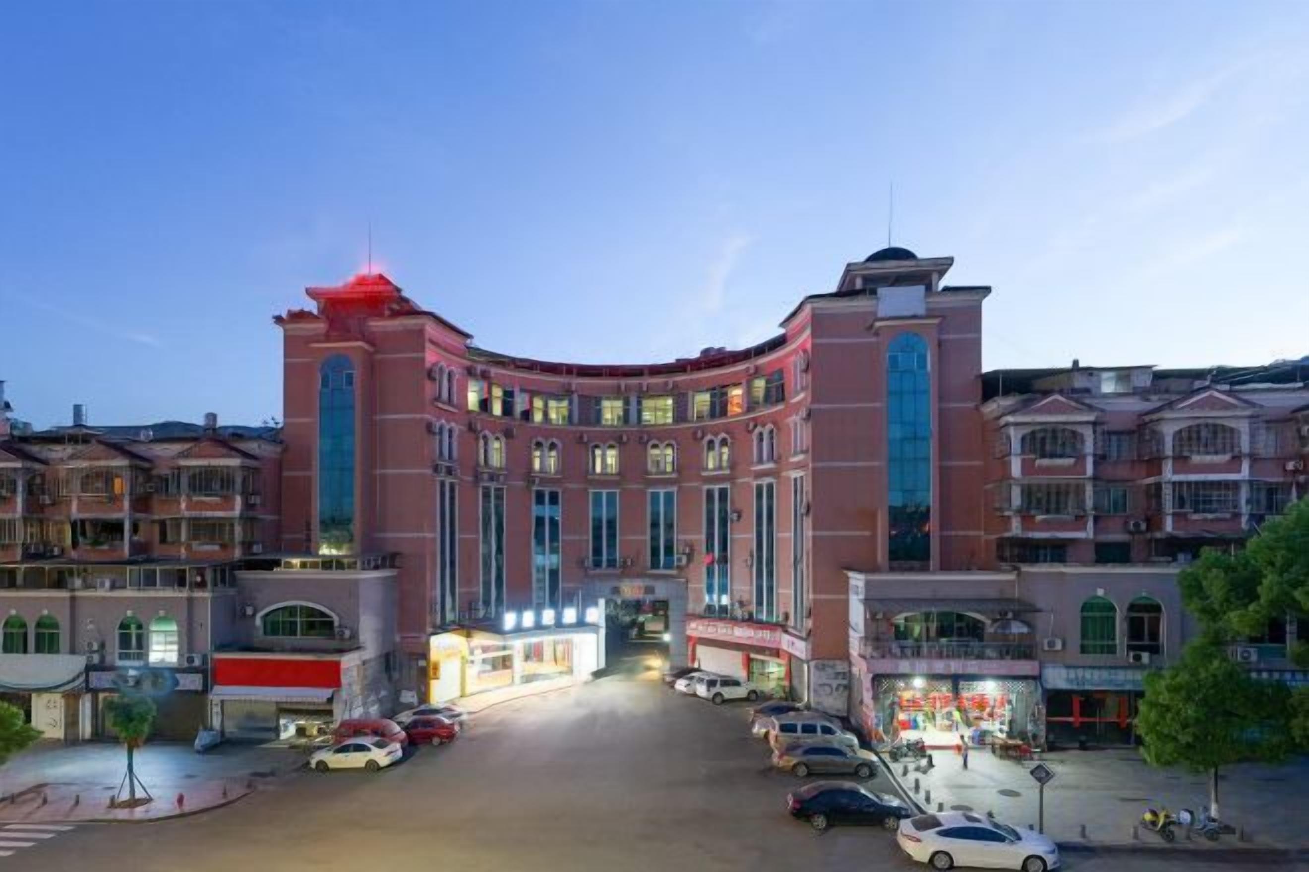 A large hotel with a curved facade, multiple floors, and a prominent entrance.