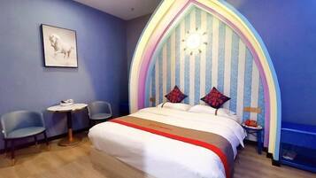 A bedroom with a bed, two chairs, a small table, and a unique striped headboard.