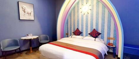 A bedroom with a bed, two chairs, a small table, and a unique striped headboard.
