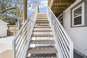 Eine Betonstufenanlage mit weißen Geländern, die zu einem Holzdeck führt.