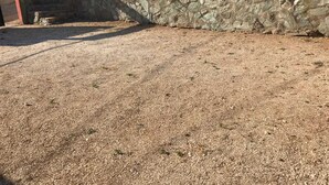 A gravel driveway leading to a stone wall with a brick building in the background. - cabaña a 10 minutos de la playa, taganga , colombia (Santa Marta)