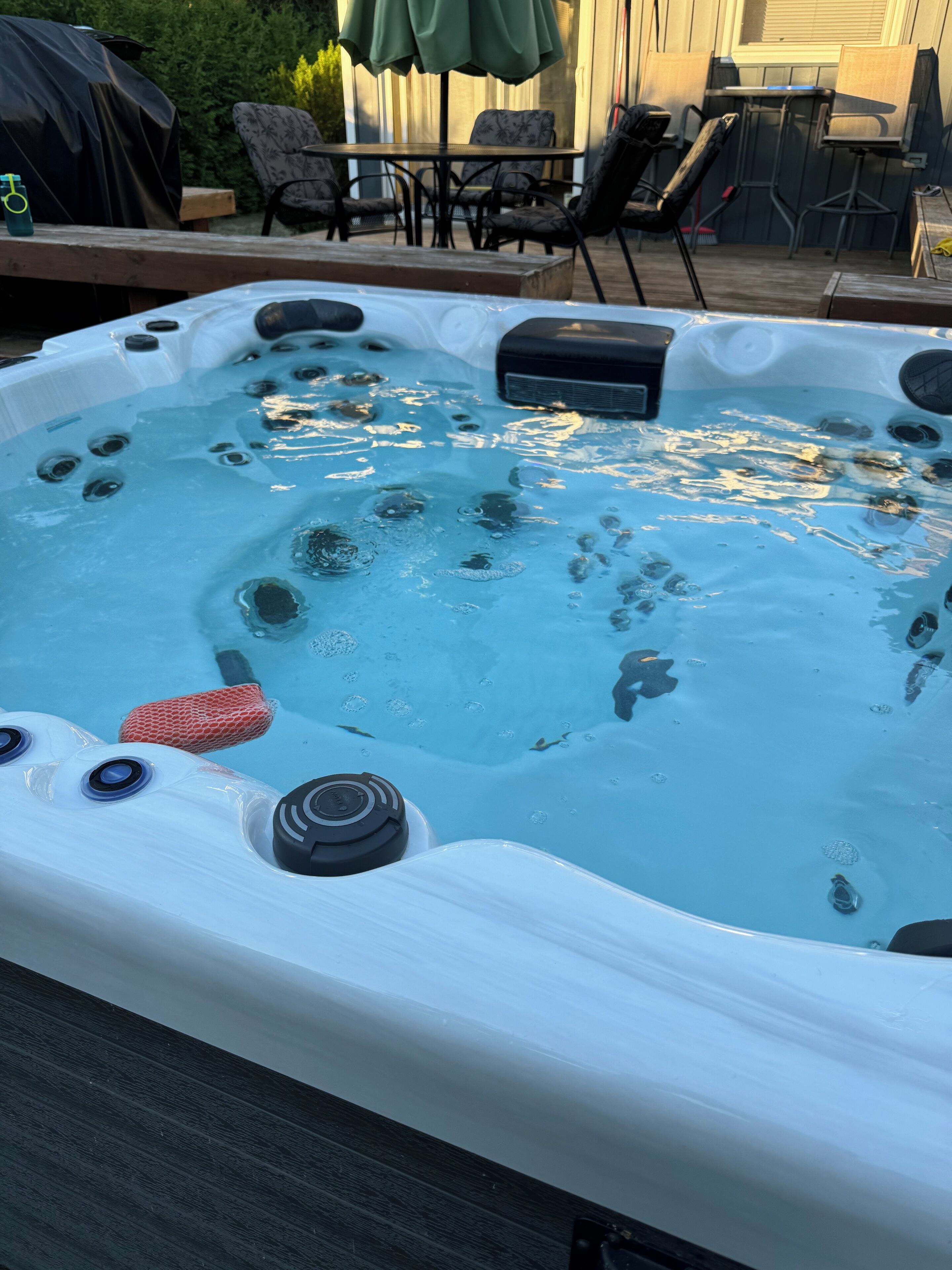 A hot tub with bubbles, a red net, and a control panel.