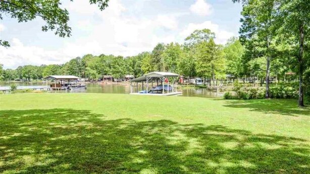 Un parque junto al lago con zonas de picnic techadas y un muelle para embarcaciones.