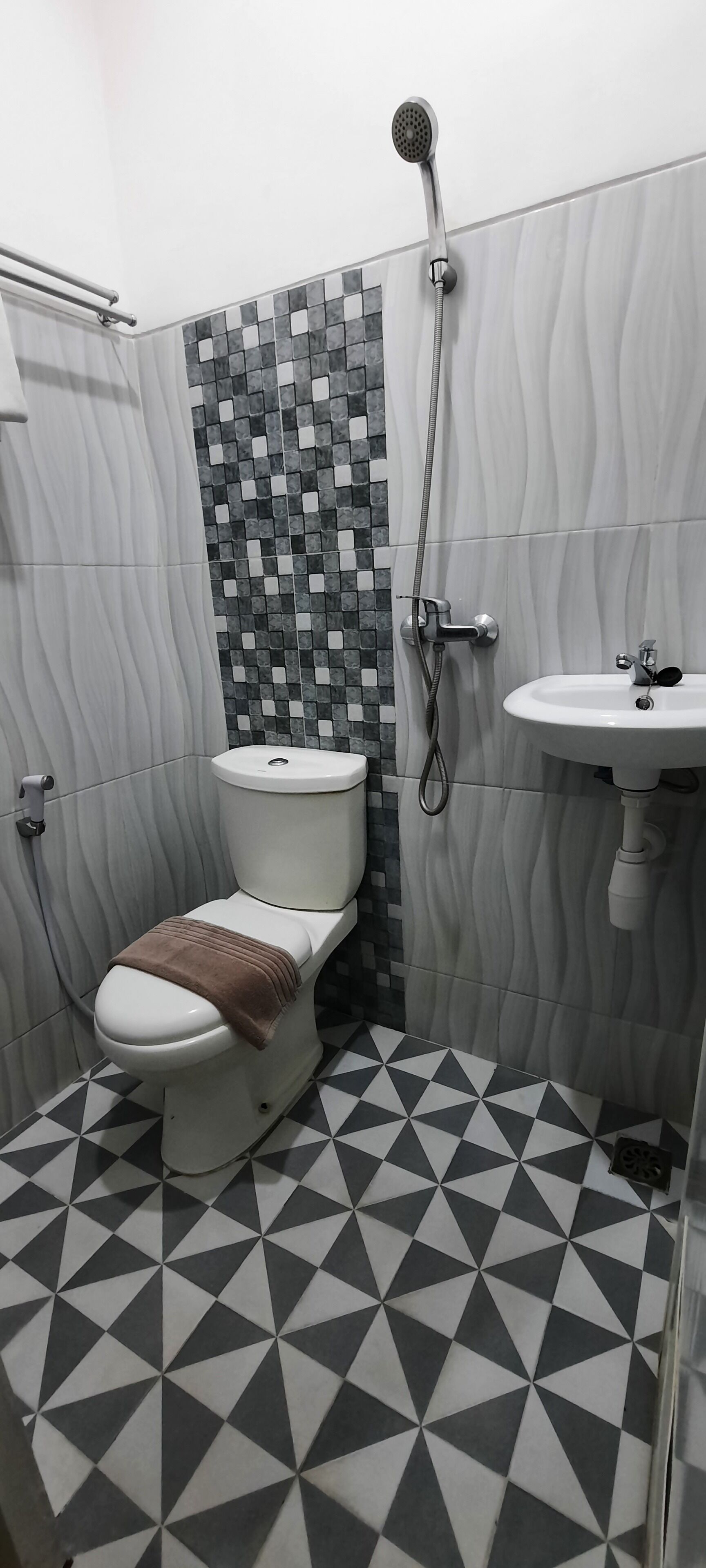 A bathroom with a toilet, a shower, and a sink.