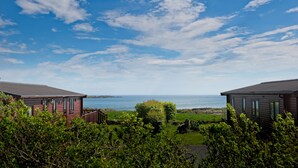 Two cabins with a view of the sea and a clear sky. - Crabtree Lodge -  a lodge that sleeps 6 guests  in 3 bedrooms (Gatehouse Of Fleet)
