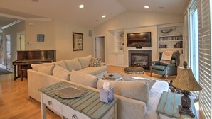 A living room with a sofa, armchairs, a coffee table, a fireplace, a television, and a bookshelf. - 4 BR, 5 BA Home, Pet Friendly, EV Charger, Community Pool, Tennis, Free Activities and Chair Lift! (Selbyville)