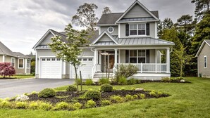 A two-story house with a front porch, garage, and well-maintained lawn. - 4 BR, 5 BA Home, Pet Friendly, EV Charger, Community Pool, Tennis, Free Activities and Chair Lift! (Selbyville)