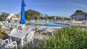 A pool area with multiple pools, lounge chairs, and umbrellas. - 4 BR, 5 BA Home, Pet Friendly, EV Charger, Community Pool, Tennis, Free Activities and Chair Lift! (Selbyville)