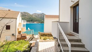 Ein Küsteneigentum mit Meerblick, einer Treppe und einem Balkon.