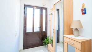 Ein Zimmer mit Holzschrank, Spiegel, Lampe und einer Topfpflanze.