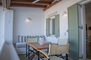Une pièce chaleureuse avec une table en bois, des chaises en osier, un banc rembourré et une lanterne tressée.