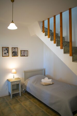 Une chambre à coucher avec un lit, une table de chevet, une lampe et un escalier.