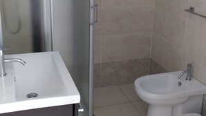 A bathroom with a shower, a sink, a bidet, and a toilet. - lu Ientu House in Otranto, Baia dei Turchi Area No001 (Otranto)