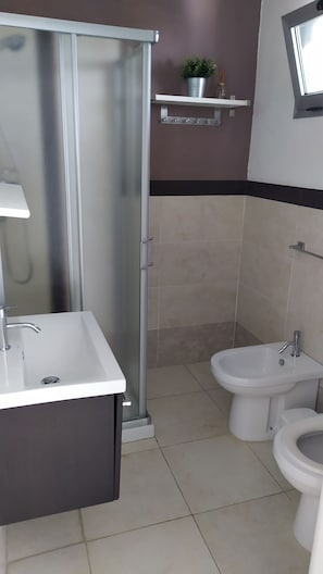 A bathroom with a shower, a sink, a bidet, and a toilet. - lu Ientu House in Otranto, Baia dei Turchi Area No001 (Otranto)